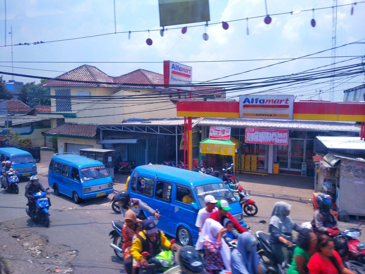 CROWD ON ROAD AGAINST SKY IN CITY IN BACKGROUND