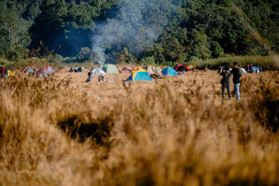 Group of people on field against trees