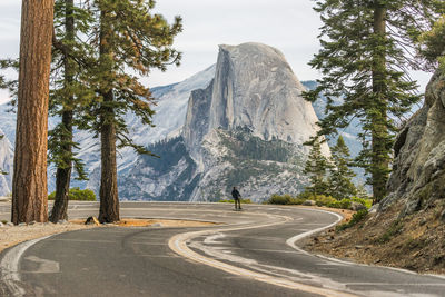 Man skateboarding on road against mountain against sky