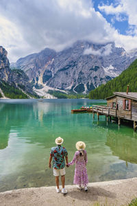 Rear view of woman standing by lake