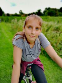 Portrait of girl riding bicycle on field