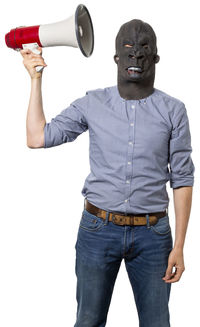 Portrait of young man with arms raised standing against white background