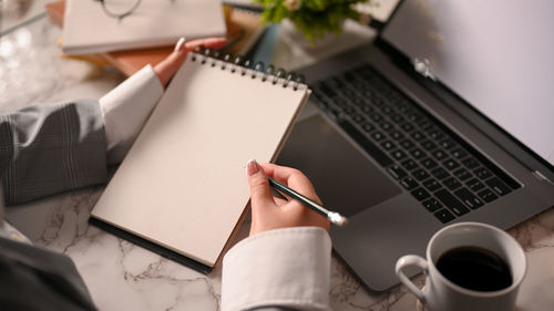 Midsection of woman using laptop on table