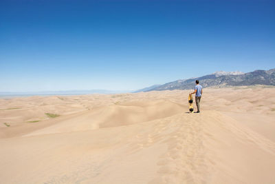 Full length of man on desert against clear sky