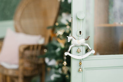 The christmas tree toy horse is hanging on the door handle of the mint cabinet