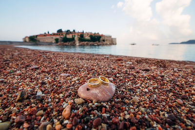 Close-up of pebbles on beach against sky