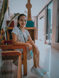 Portrait of young woman sitting at home