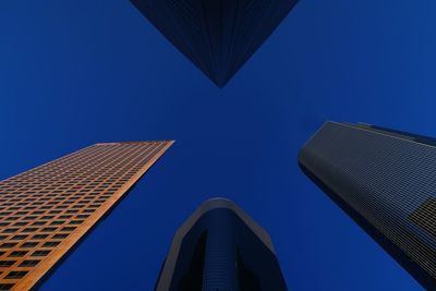 Low angle view of modern buildings against clear blue sky