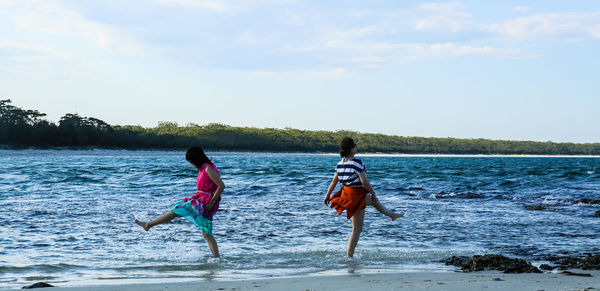 People on beach against sky