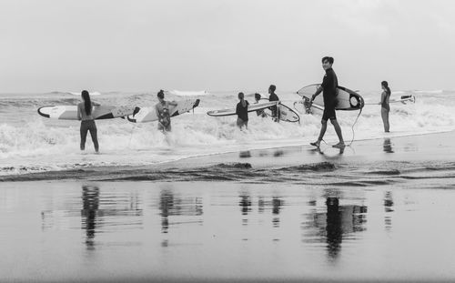 People on beach against sky