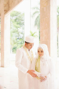 Portrait of bride standing against wall