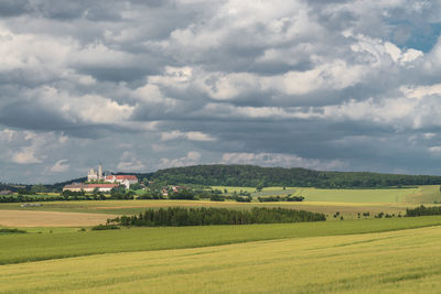 Scenic view of grassy field against cloudy sky