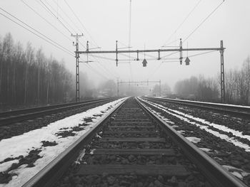 Railroad tracks against sky during winter