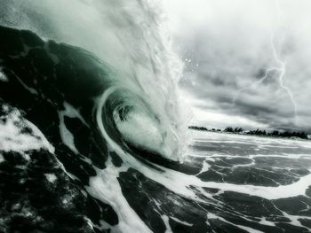 Close-up of sea wave against storm clouds