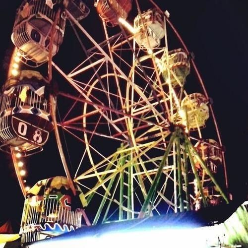 amusement park, low angle view, amusement park ride, illuminated, arts culture and entertainment, ferris wheel, night, sky, decoration, celebration, art and craft, lighting equipment, art, built structure, multi colored, fun, creativity, carousel, cultures, architecture
