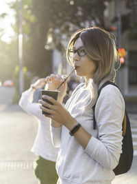 Young woman drinking water from coffee