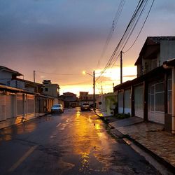 Road passing through city at sunset