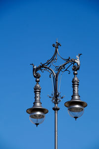 Low angle view of ornate street light against clear sky