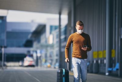 Young man using mobile phone in city