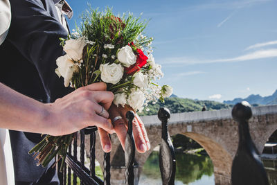 Man and woman hands with wedding rings and bouquet