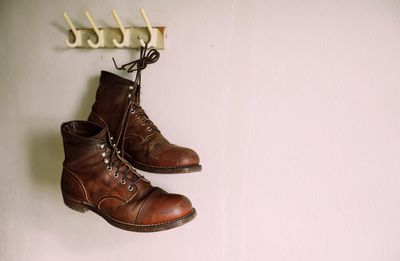 Close-up of shoes hanging against wall