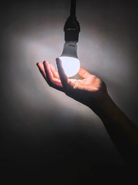 Close-up of hand holding camera over white background