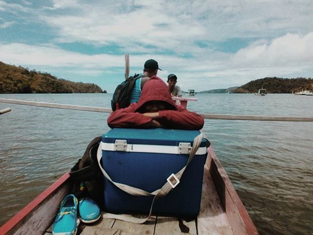 water, nautical vessel, transportation, boat, sky, mode of transport, mountain, sea, rear view, tranquility, tranquil scene, sitting, lifestyles, cloud - sky, scenics, leisure activity, men, nature