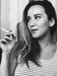 Portrait of young woman smoking cigarette