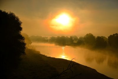 Scenic view of silhouette trees against orange sky