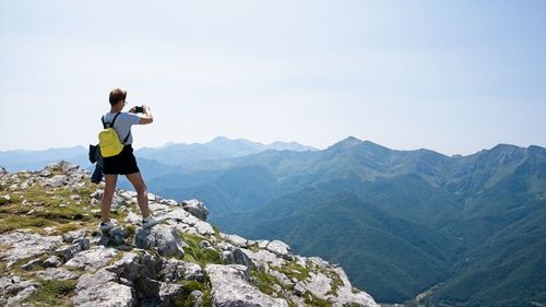 Full length of man standing on mountain against sky