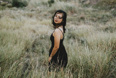 Side view of young woman standing on field