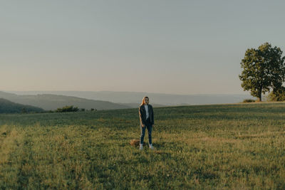 Full length of woman standing on field against sky