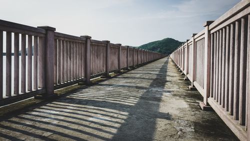 Empty footbridge against sky