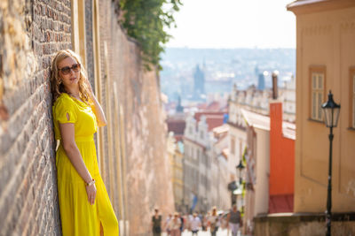 Woman in yellow dress traveling in city