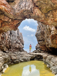 Man standing on rock by water