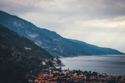 Scenic view of sea by mountains against sky