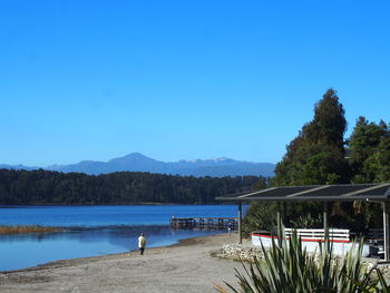 Scenic view of lake against clear blue sky