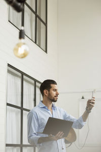 Businessman taking selfie while using laptop in office