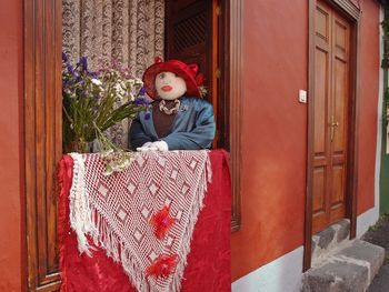 Boy sitting by door of house