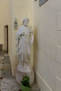 Statue of buddha against wall in building