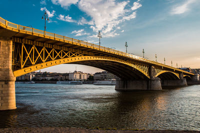 Bridge over river against sky in city