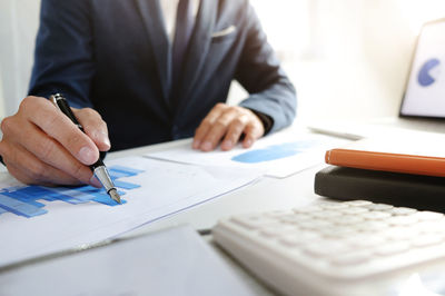 Midsection of man working on table