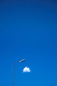 Low angle view of street light against blue sky