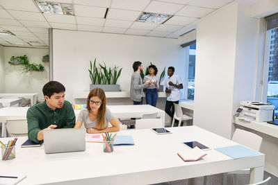 View of cheerful colleagues working in office