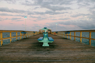 Pier over sea against sky during sunset