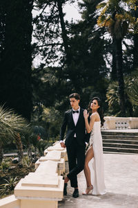 A beautiful couple in love, bride and groom in wedding clothes, walk and pose in the park in nature