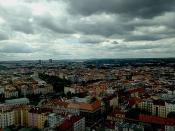 Aerial view of cityscape against cloudy sky