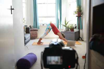 Female athlete doing exercise video recording with camera at home