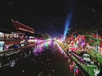 Illuminated bridge over canal in city at night