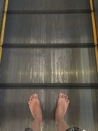 Low section of woman on escalator